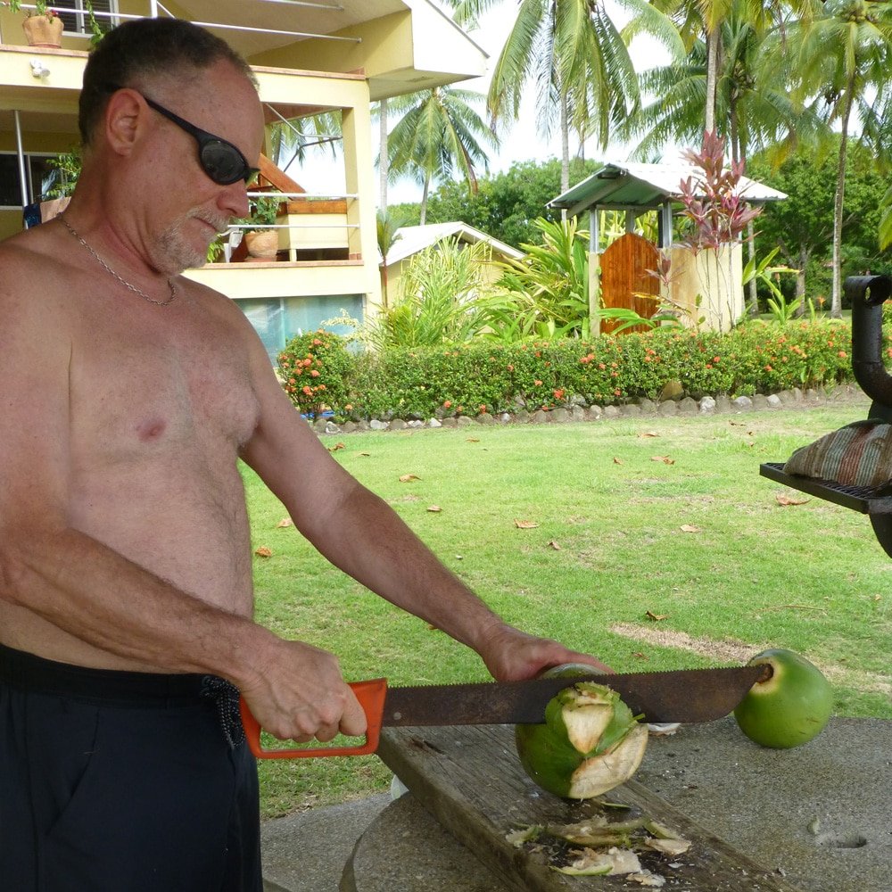 Cutting open a young coconut with a machete